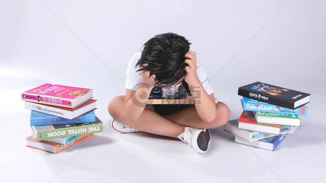 小孩子在书堆中疲劳困扰图片素材免费下载
