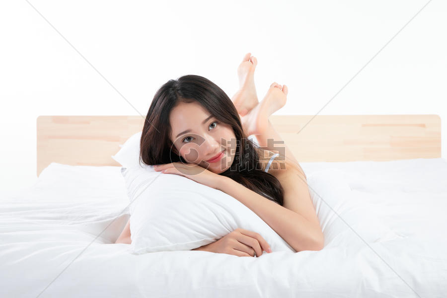 年轻女性趴在床上玩图片素材免费下载