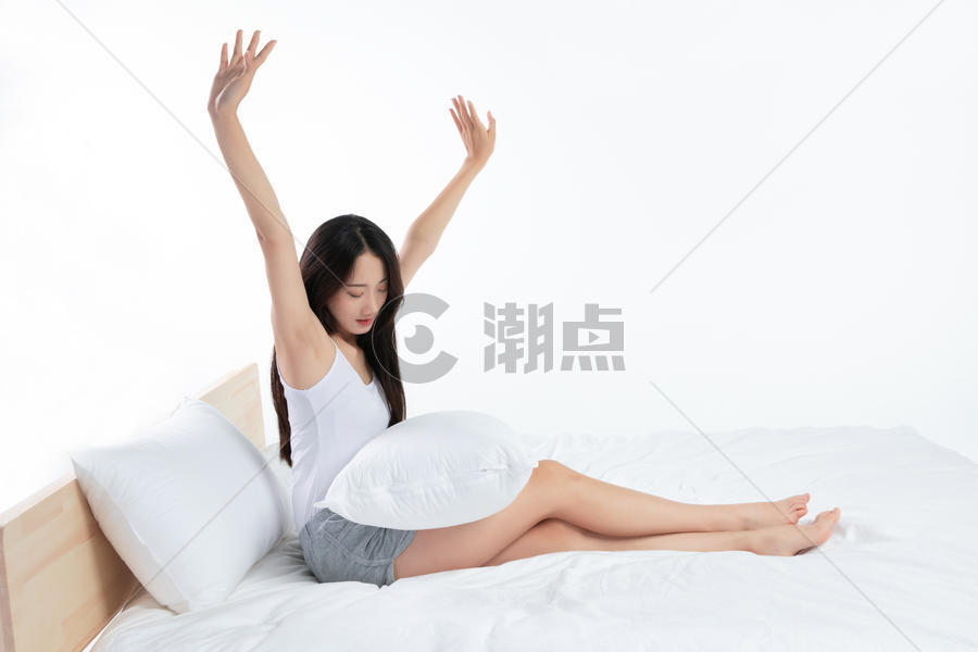 年轻女性床上伸懒腰图片素材免费下载