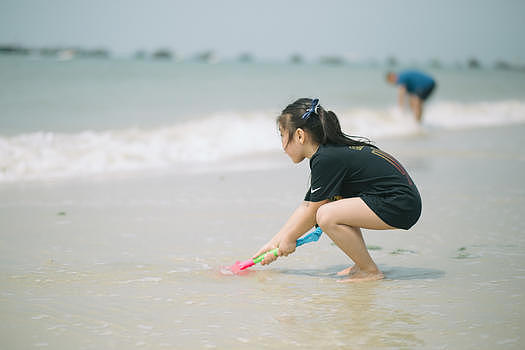 海边玩水的小女孩图片素材免费下载
