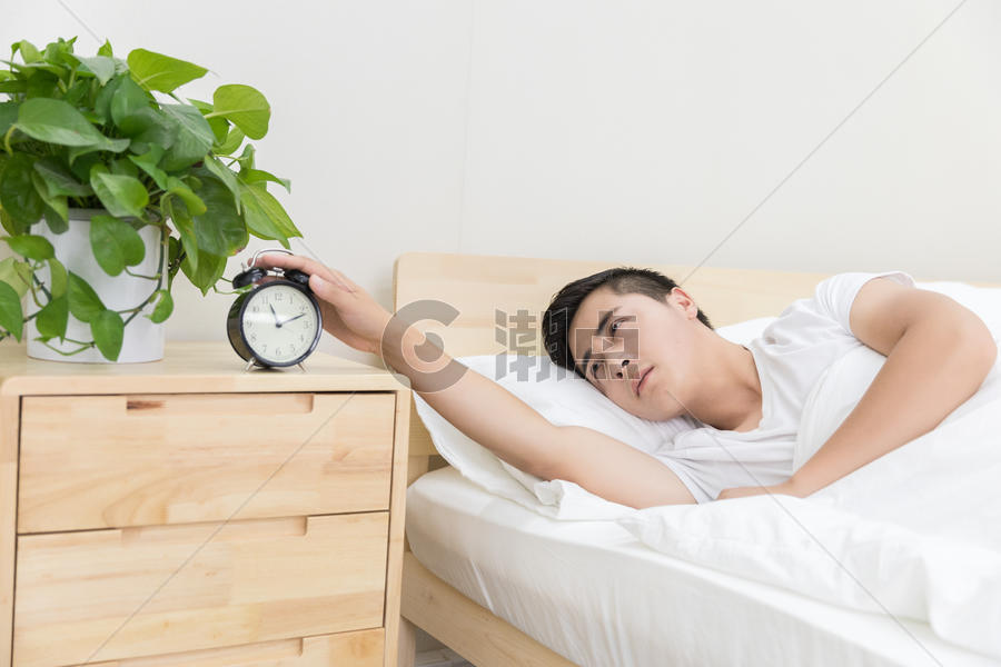 男性睡觉被闹钟吵醒图片素材免费下载