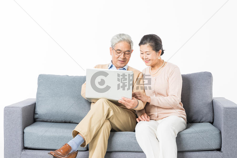 沙发上老年夫妻用电脑图片素材免费下载