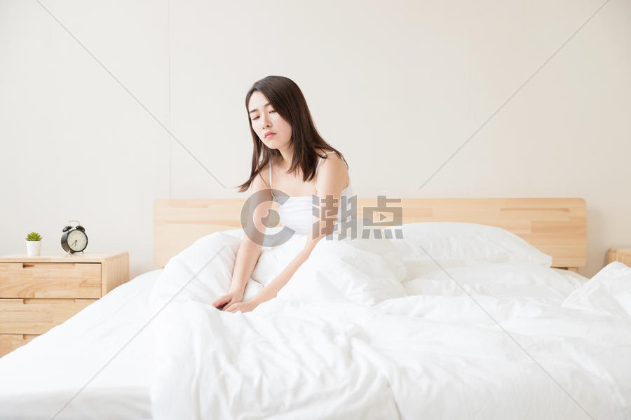 年轻女性醒来坐床上图片素材免费下载
