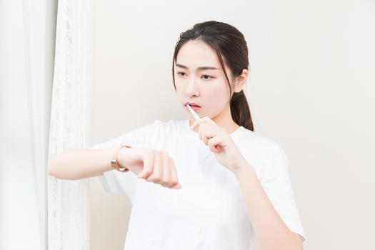 年轻女性刷牙看手表图片素材免费下载