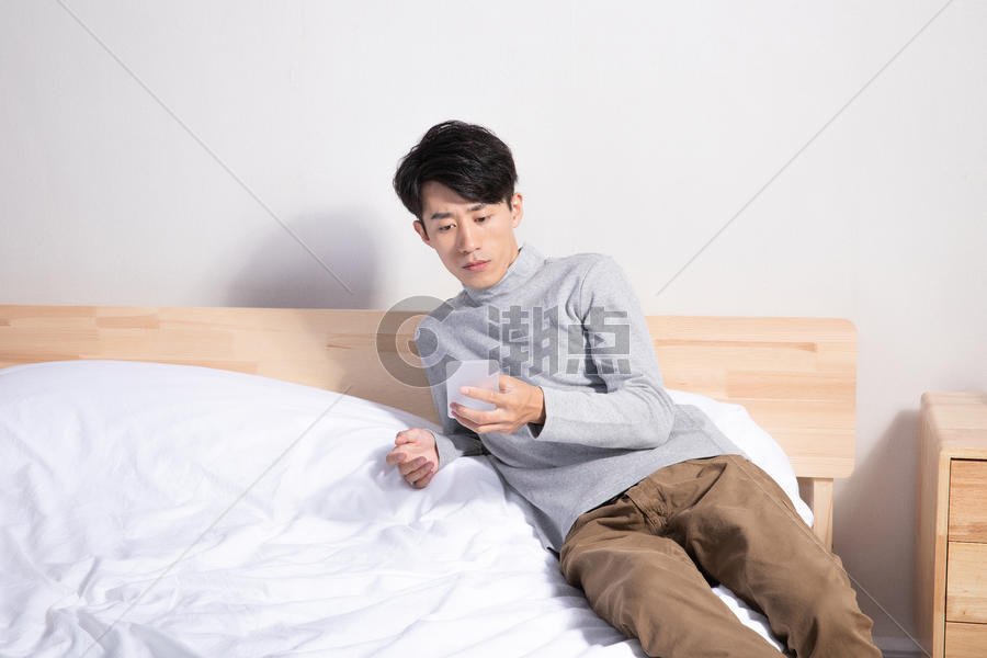 躺在床上玩手机的男性图片素材免费下载