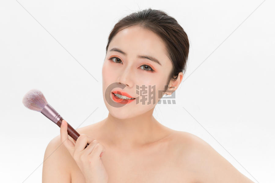 女性化妆拿粉底刷图片素材免费下载