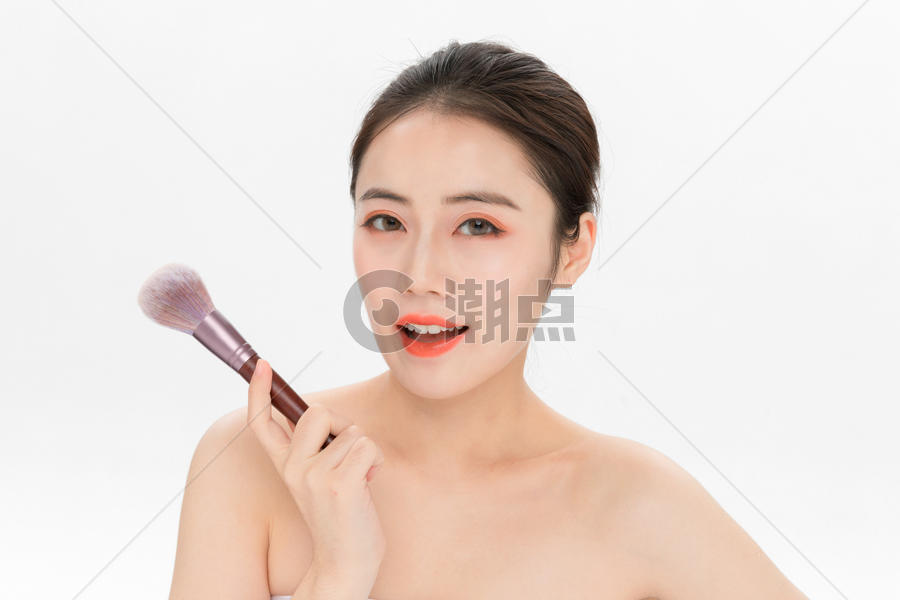 女性化妆拿粉底刷图片素材免费下载