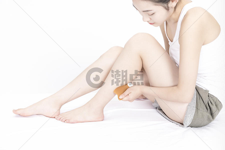 女性用刮痧板按摩腿部图片素材免费下载