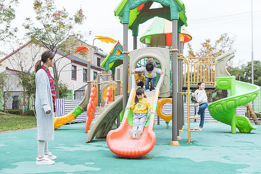 户外幼师带儿童玩滑滑梯图片素材免费下载