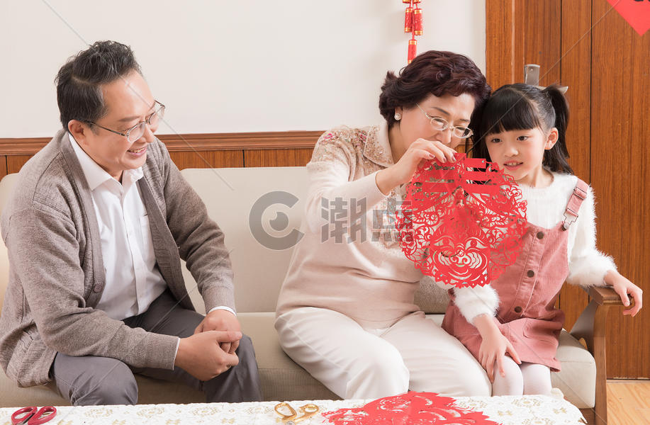 春节爷爷奶奶教孩子剪窗花图片素材免费下载