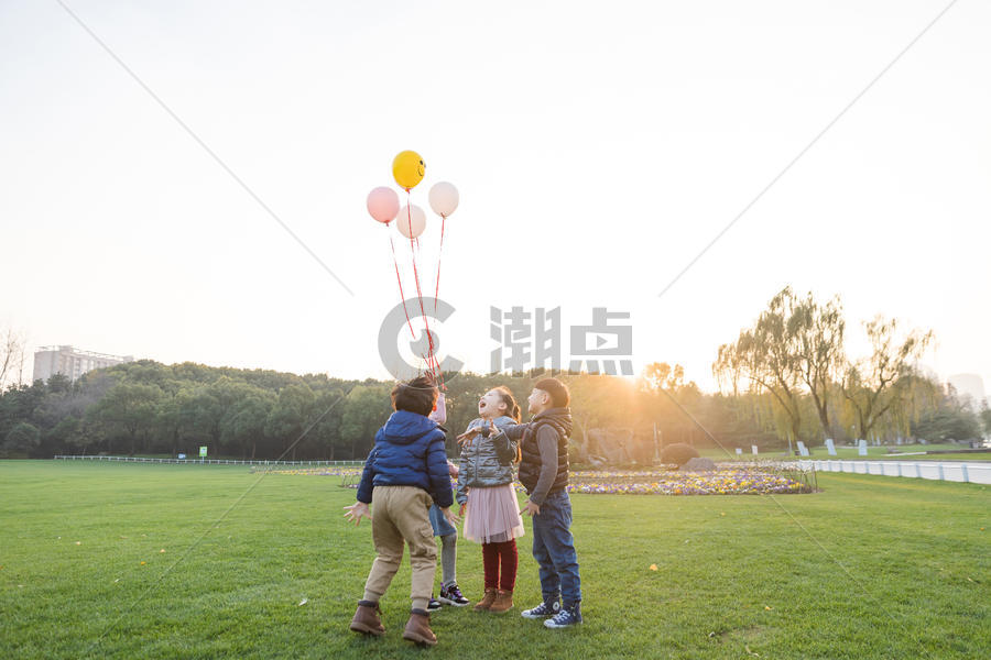 夕阳下儿童们共同放气球图片素材免费下载