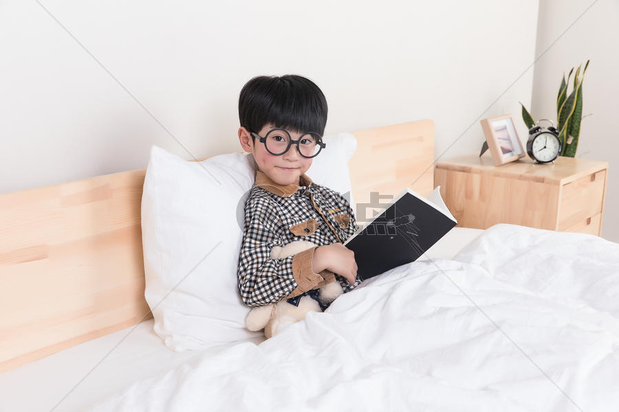 在床上看书的小男孩图片素材免费下载