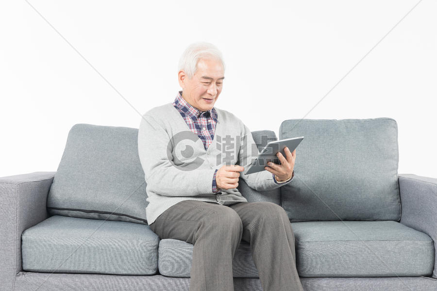 老人在沙发上看平板电脑图片素材免费下载
