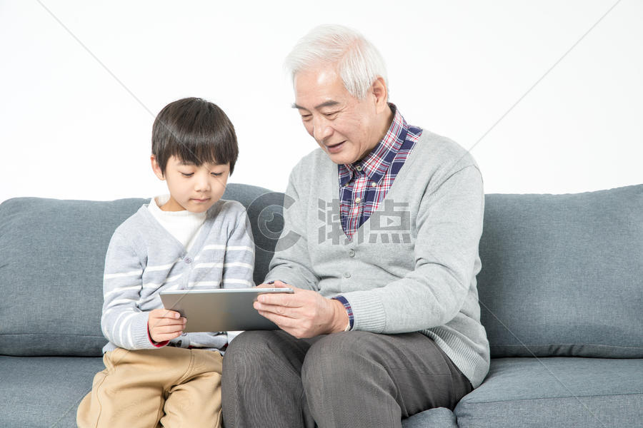 祖孙在沙发上使用平板电脑图片素材免费下载