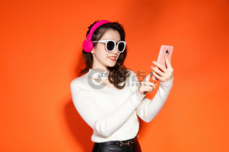 穿着时髦的女性拿着手机图片素材免费下载