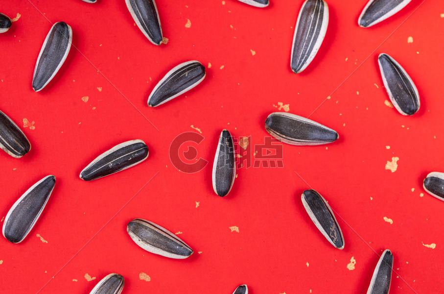 红色背景下的葵花籽图片素材免费下载