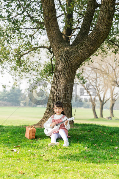 女孩在草坪上弹吉他图片素材免费下载
