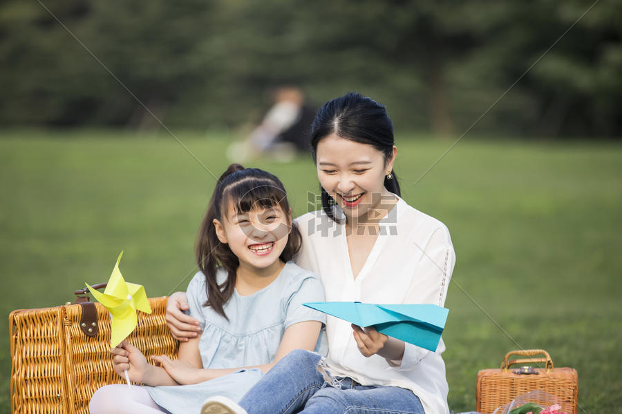 妈妈和女儿在草坪上玩纸飞机图片素材免费下载