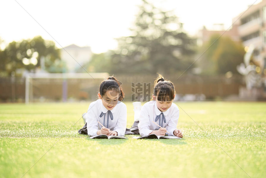 小学生趴在操场学习图片素材免费下载