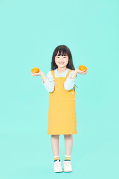 小女孩拿橙子图片素材免费下载
