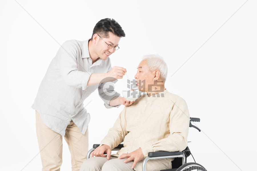 老年父子轮椅上喂食图片素材免费下载