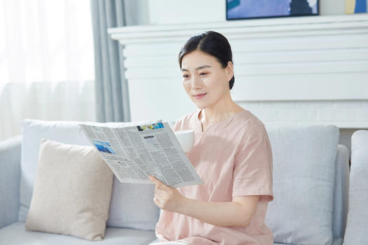 中年女性在家看报纸图片素材免费下载