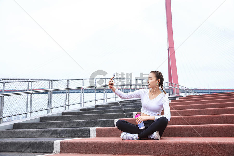 运动女性休息玩手机图片素材免费下载
