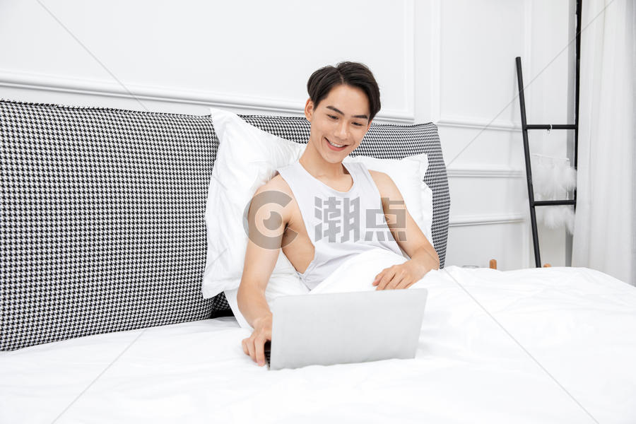 居家男青年床上用电脑图片素材免费下载