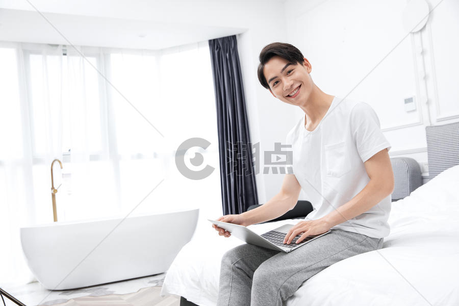 男青年卧室床上用电脑图片素材免费下载