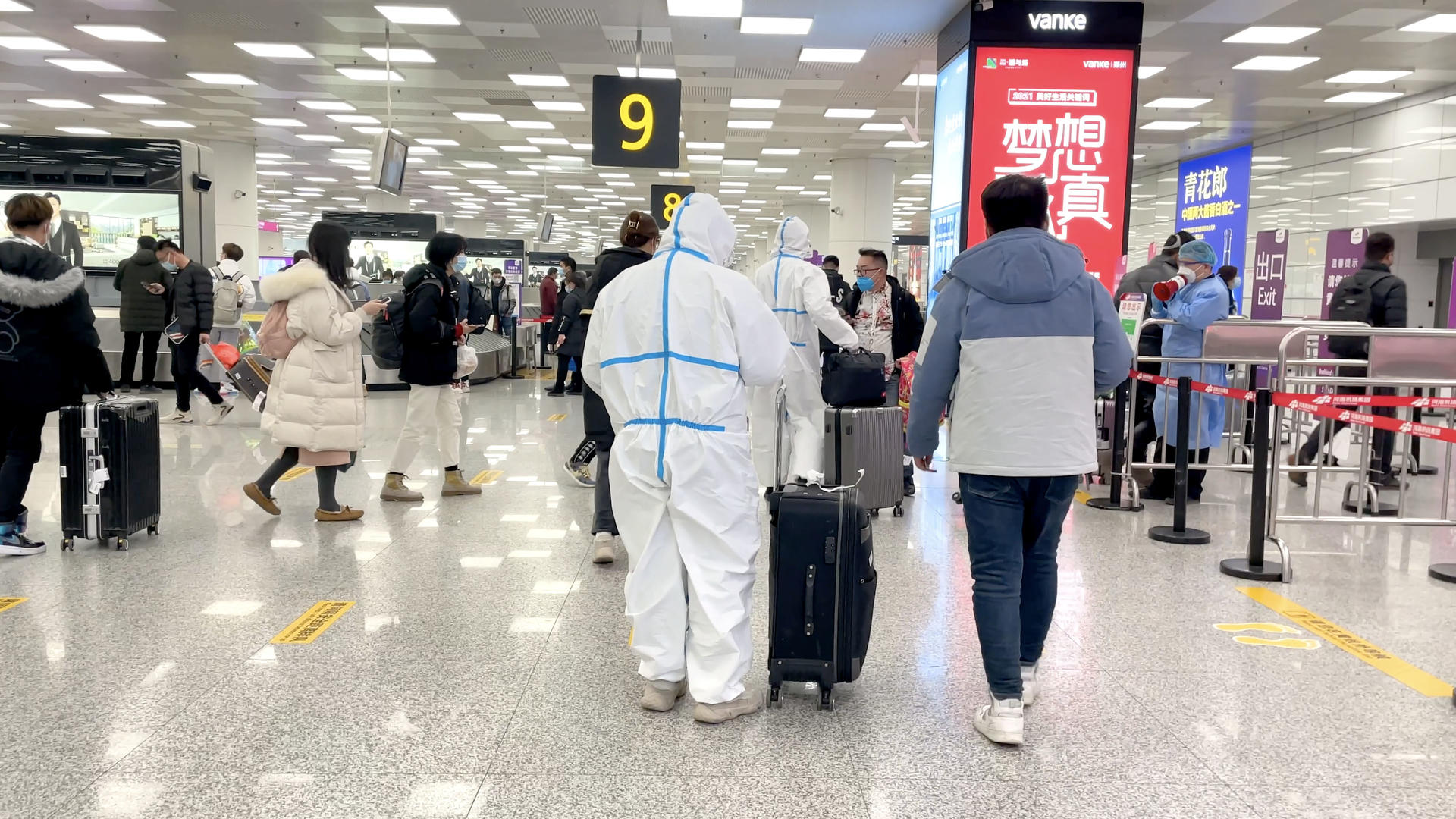 郑州新郑国际机场T2航站楼穿着防护服拉着行李箱出站的旅客视频的预览图