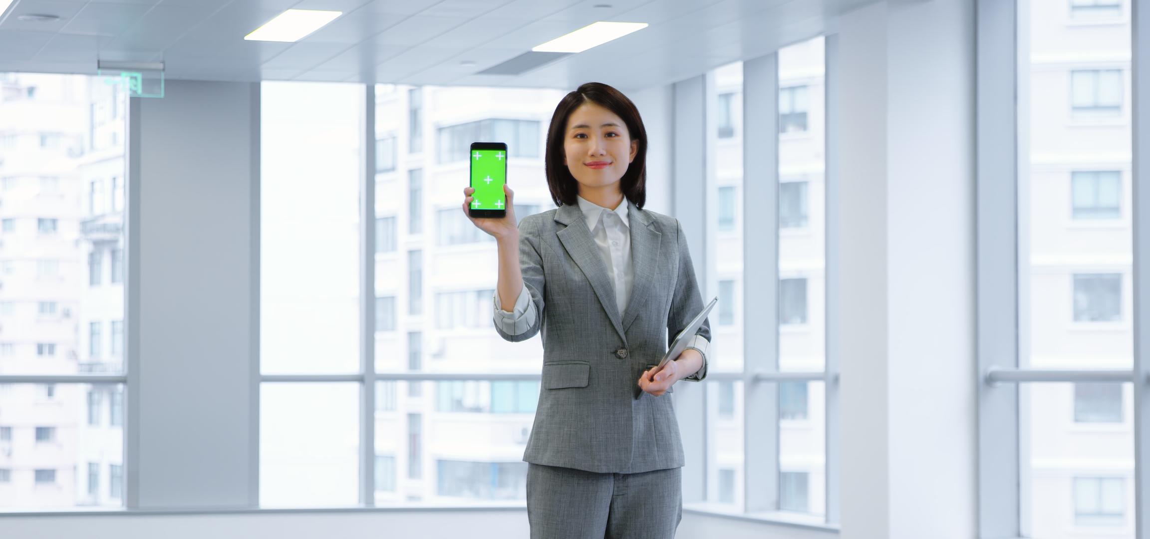 职场商务女性展示手机绿幕视频的预览图