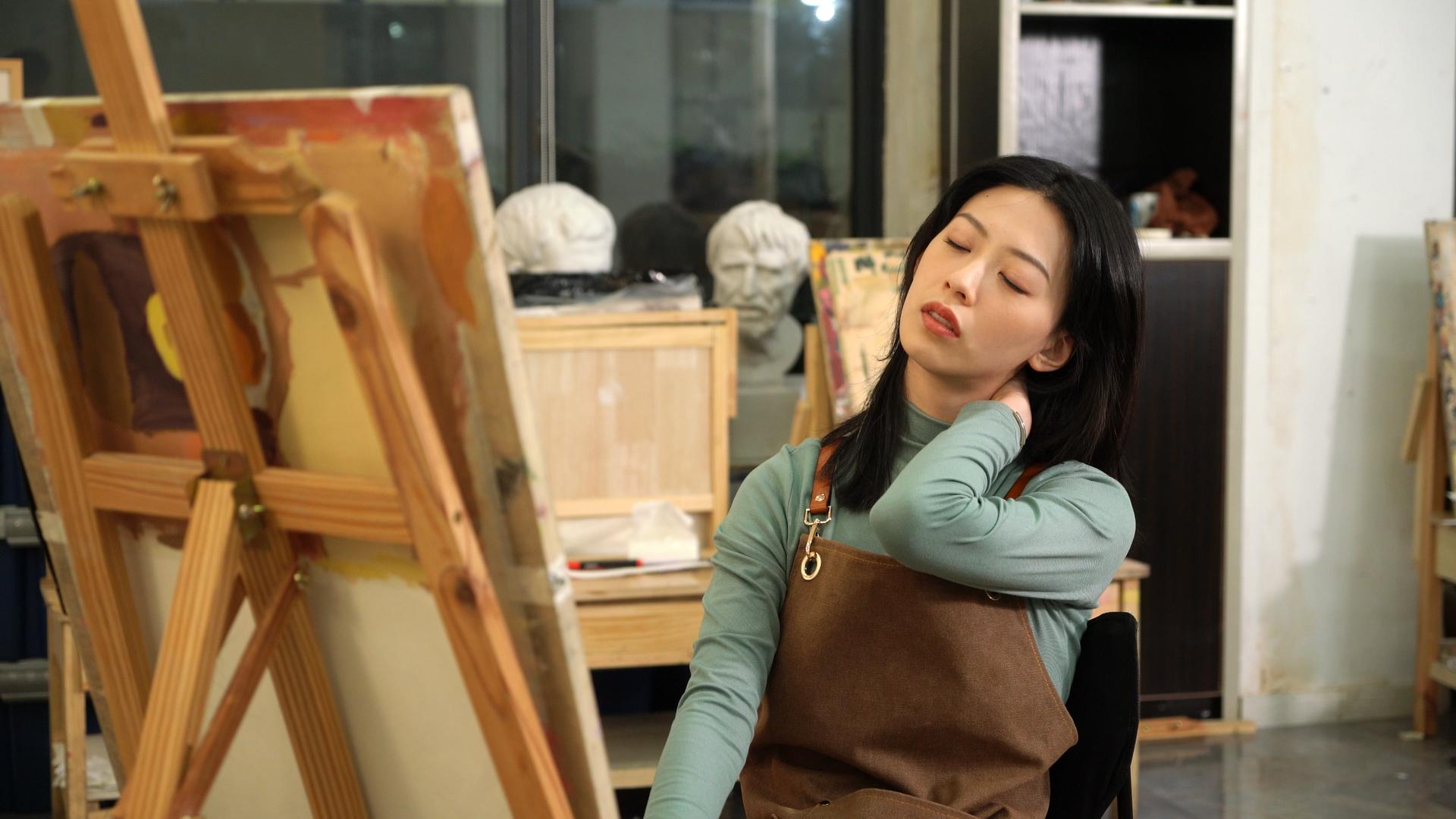 疲惫的艺术类高考奋战的女学生夜晚在画室画画视频的预览图