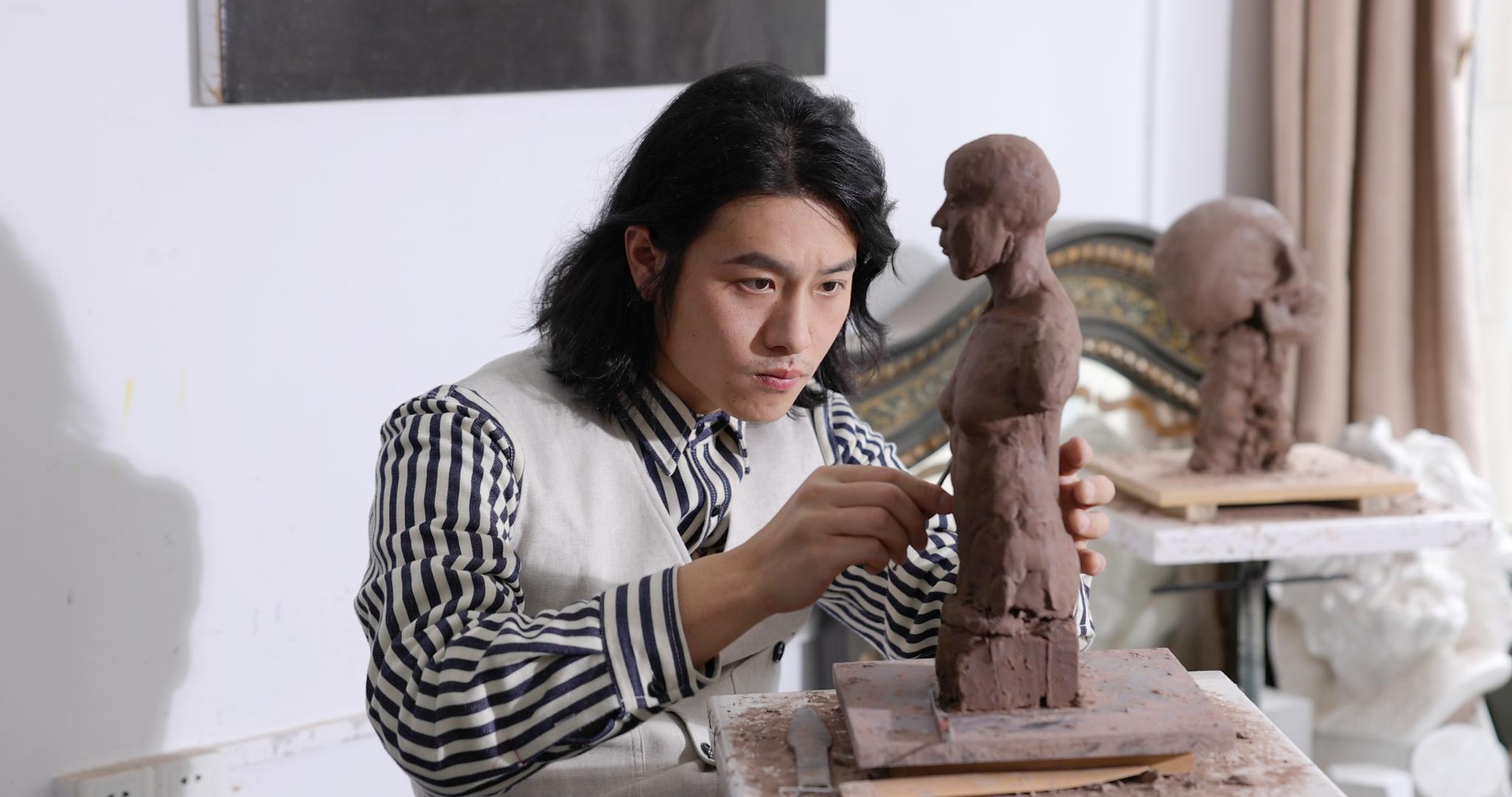 年轻男艺术家专注雕刻塑像作品视频的预览图