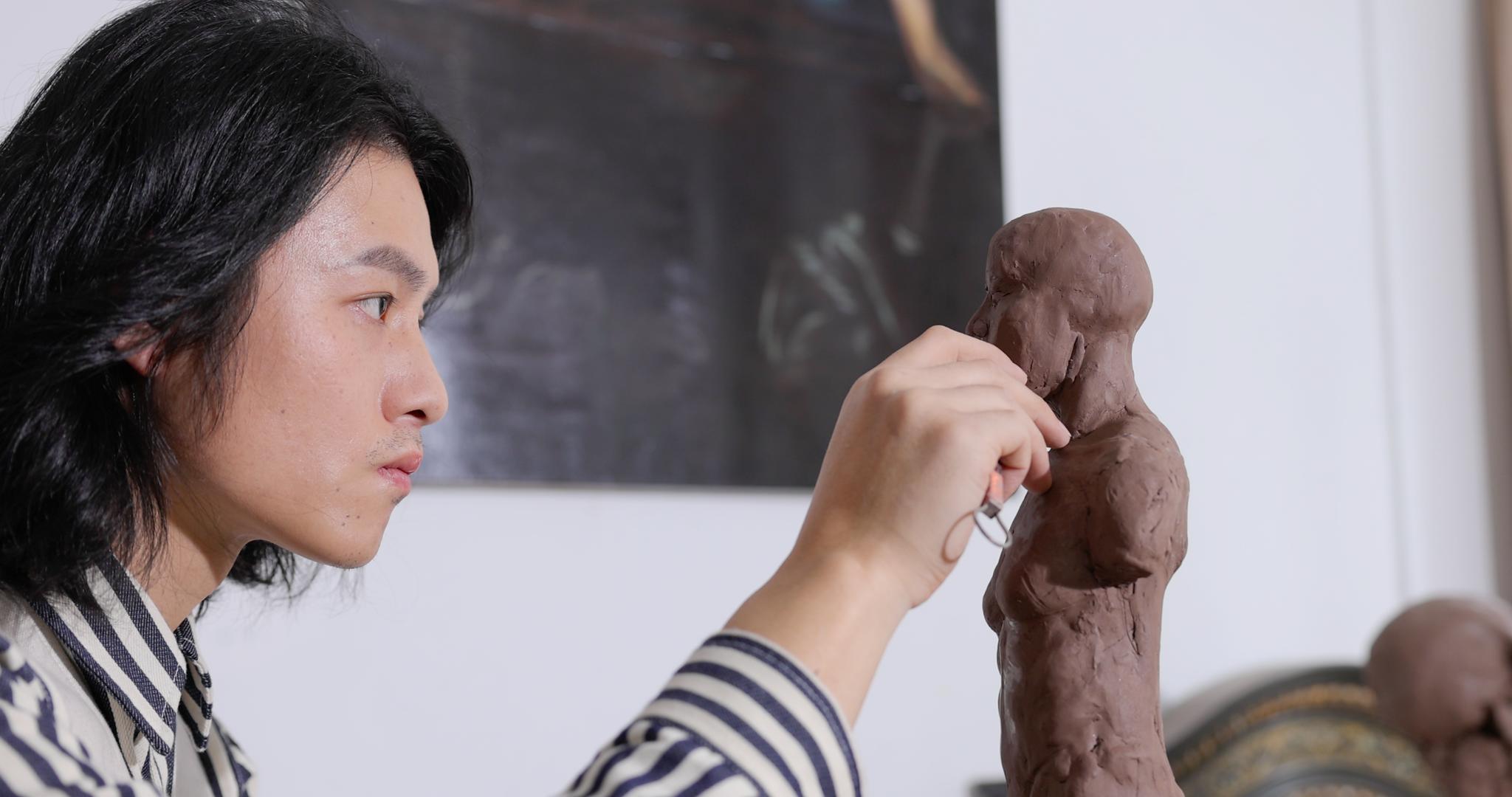 年轻男艺术家专注雕刻塑像视频的预览图
