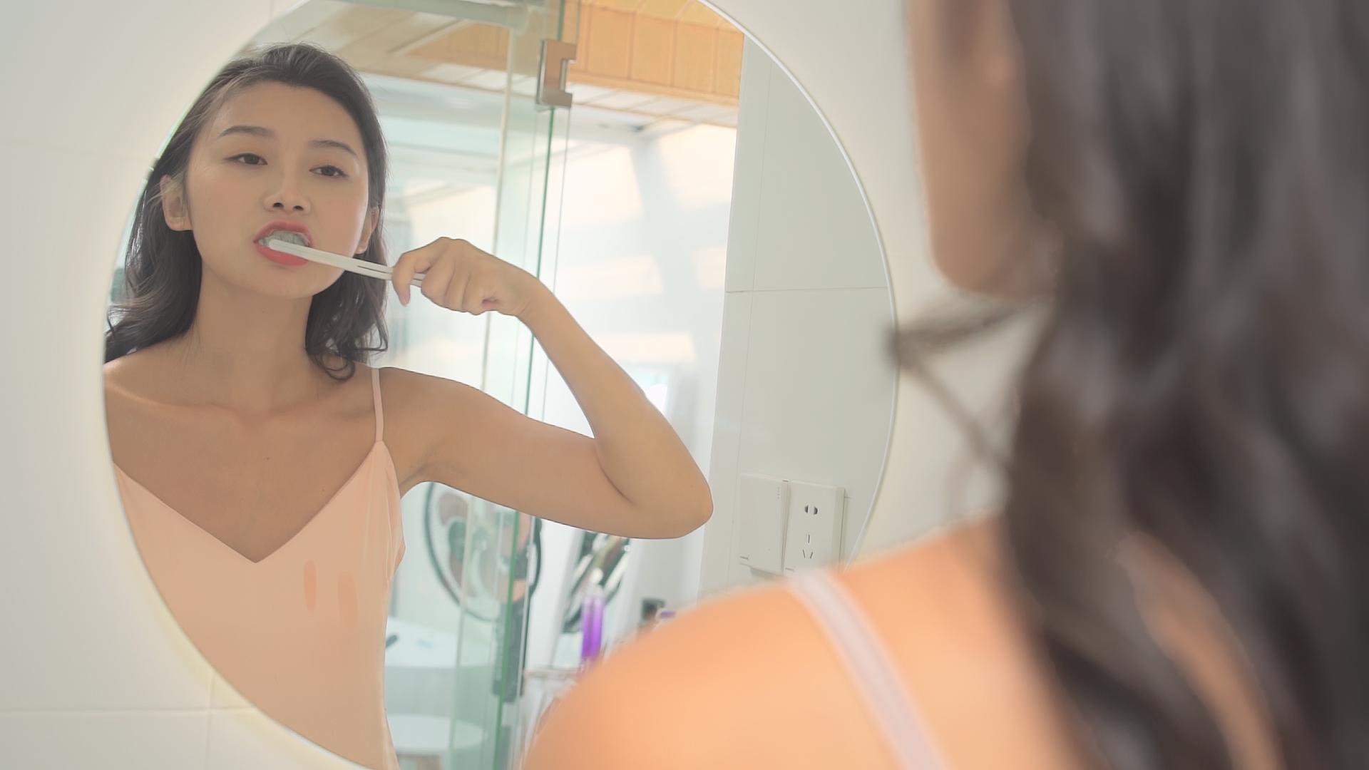 女性在卫生间对着镜子刷牙视频的预览图