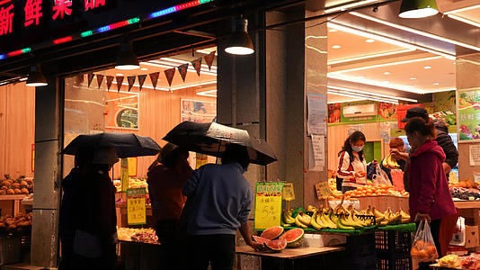 城市雨天夜晚街景夜市水果店购物的人群4k素材视频的预览图