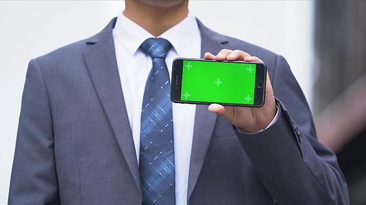 4k穿西装的办公男生展示绿幕手机视频的预览图
