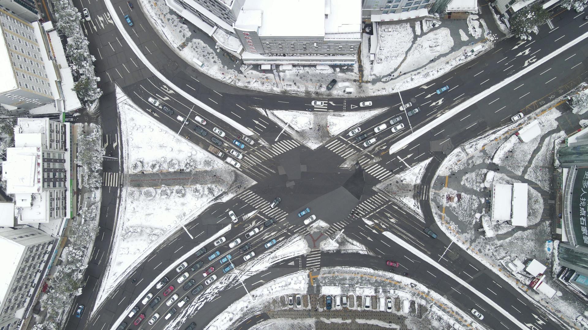 4K俯拍冬天城市雪景交通车辆行驶视频的预览图