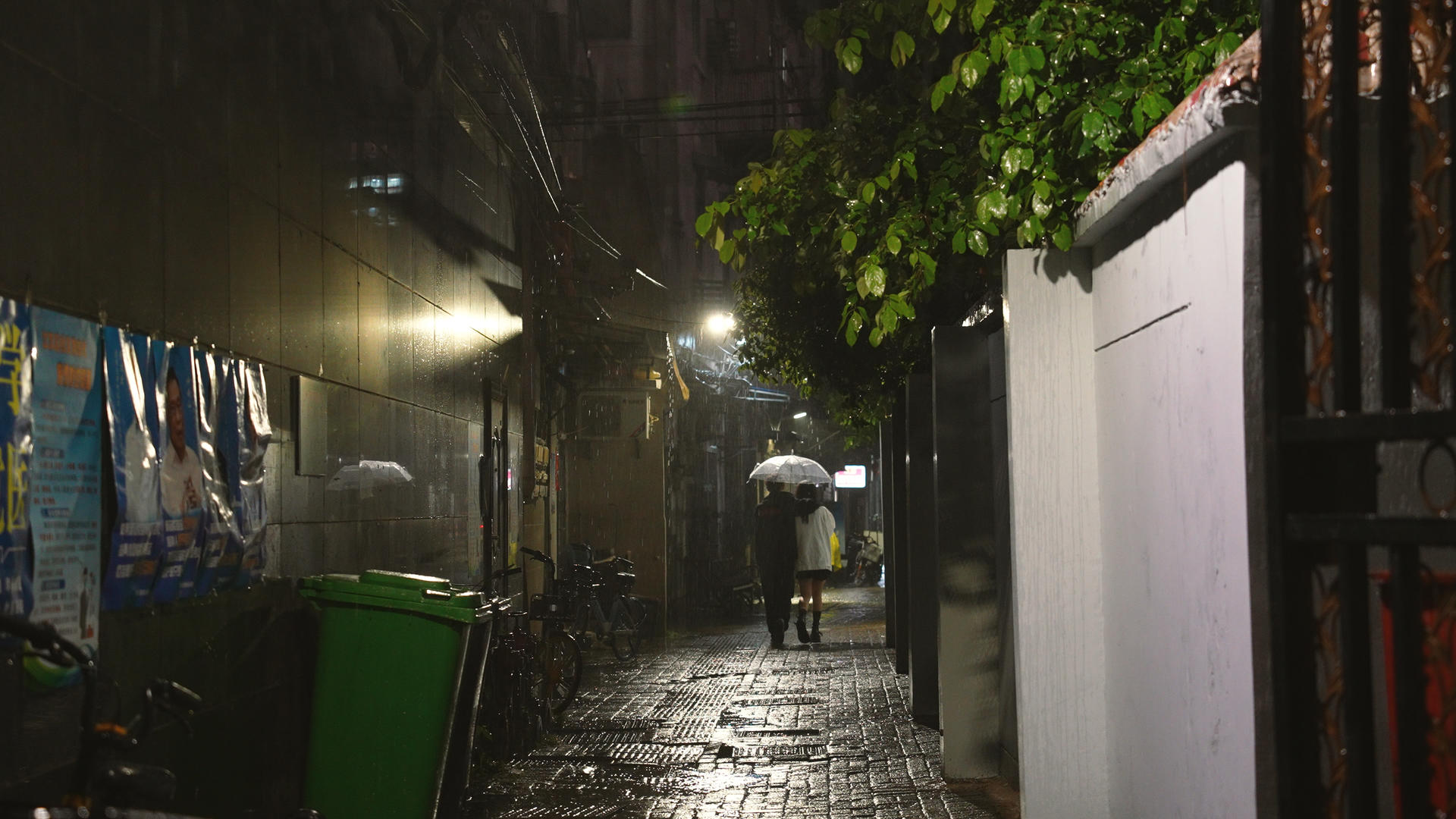 4k素材慢动作升格拍摄城市雨天夜晚路灯下回家的情侣背影视频的预览图