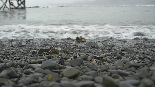海浪冲上小石头海滩视频的预览图
