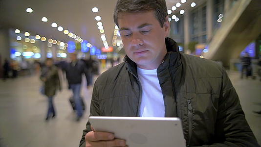 在机场或火车终点站持有平板电脑的人视频的预览图