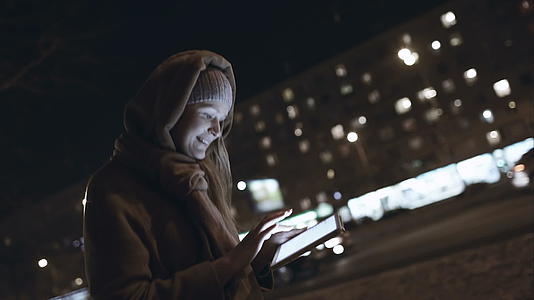 晚上在城市路上打字的女人身上有触摸板视频的预览图