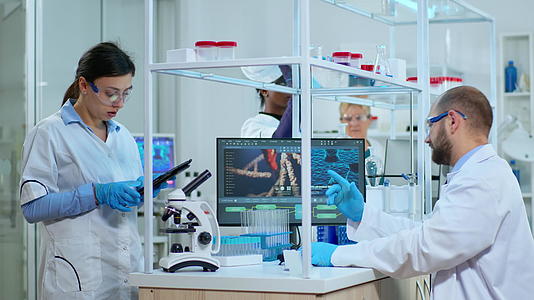 科学家和护士在实验室的平板药片上做笔记视频的预览图