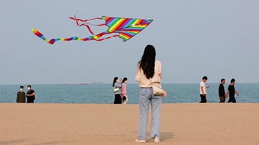 4K沙滩上女人放风筝的美丽风筝视频的预览图
