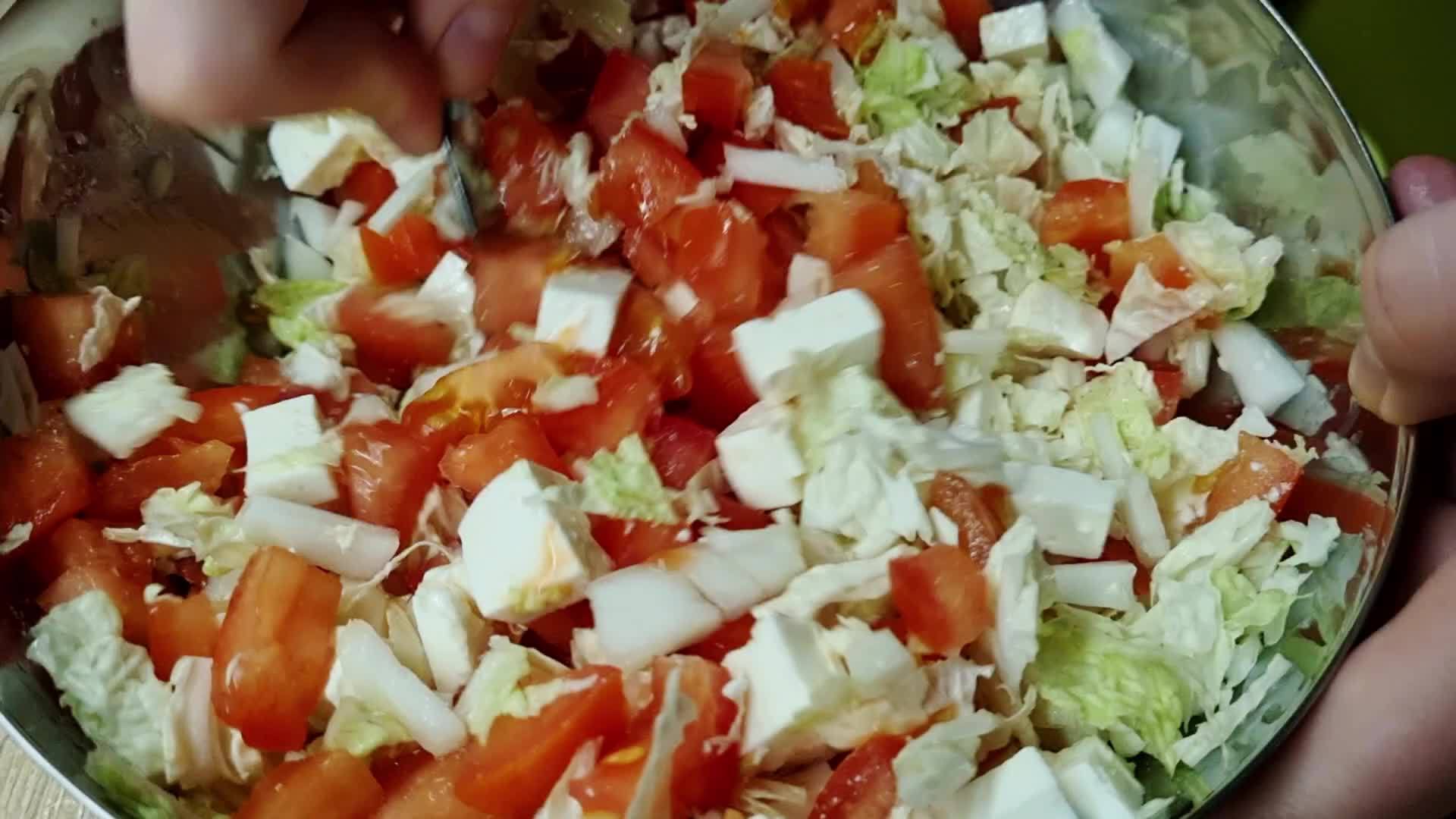 用勺子搅拌卷心菜和番茄沙拉视频的预览图