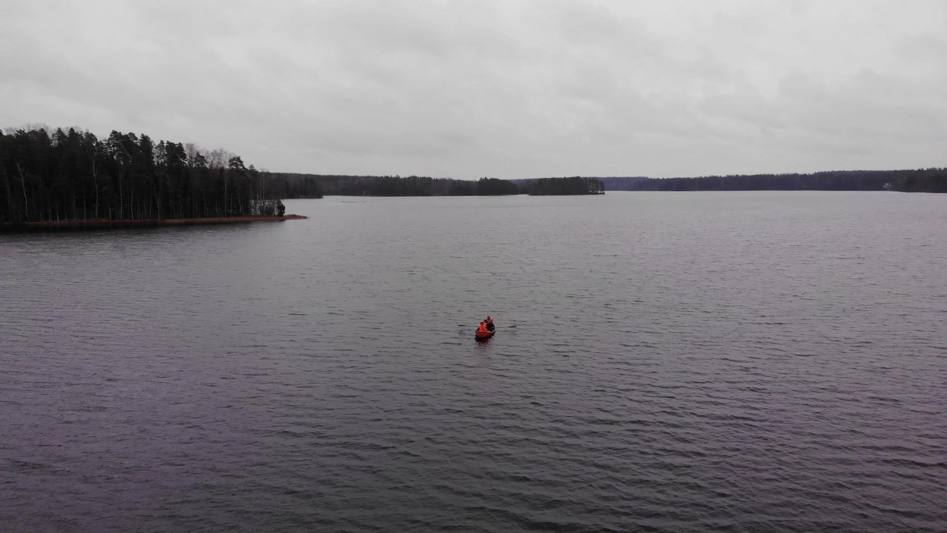 秋天三个人在芬兰湖上乘坐橙色的船视频的预览图