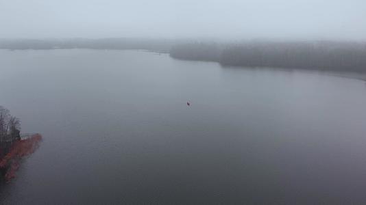 孤独的橙色船和法尔曼在芬兰空中湖边的浓雾中视频的预览图