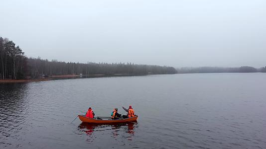 三个人在芬兰浓雾的秋湖上的小橙色船上钓鱼视频的预览图