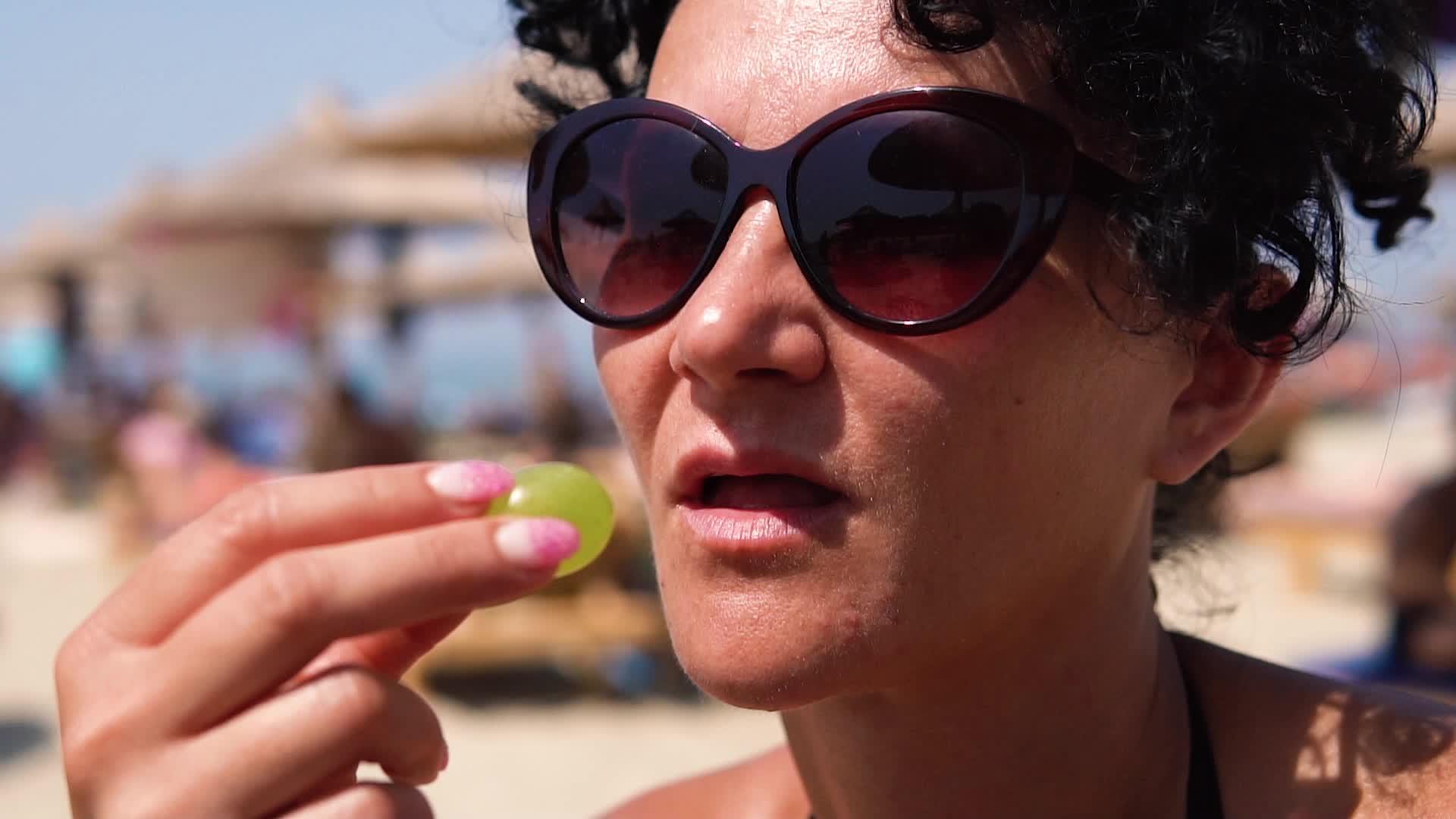 女人在沙滩上慢慢地吃葡萄视频的预览图