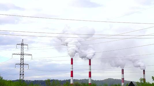 多云天空下的浓烟工业厂房管道和高压输电线路视频的预览图